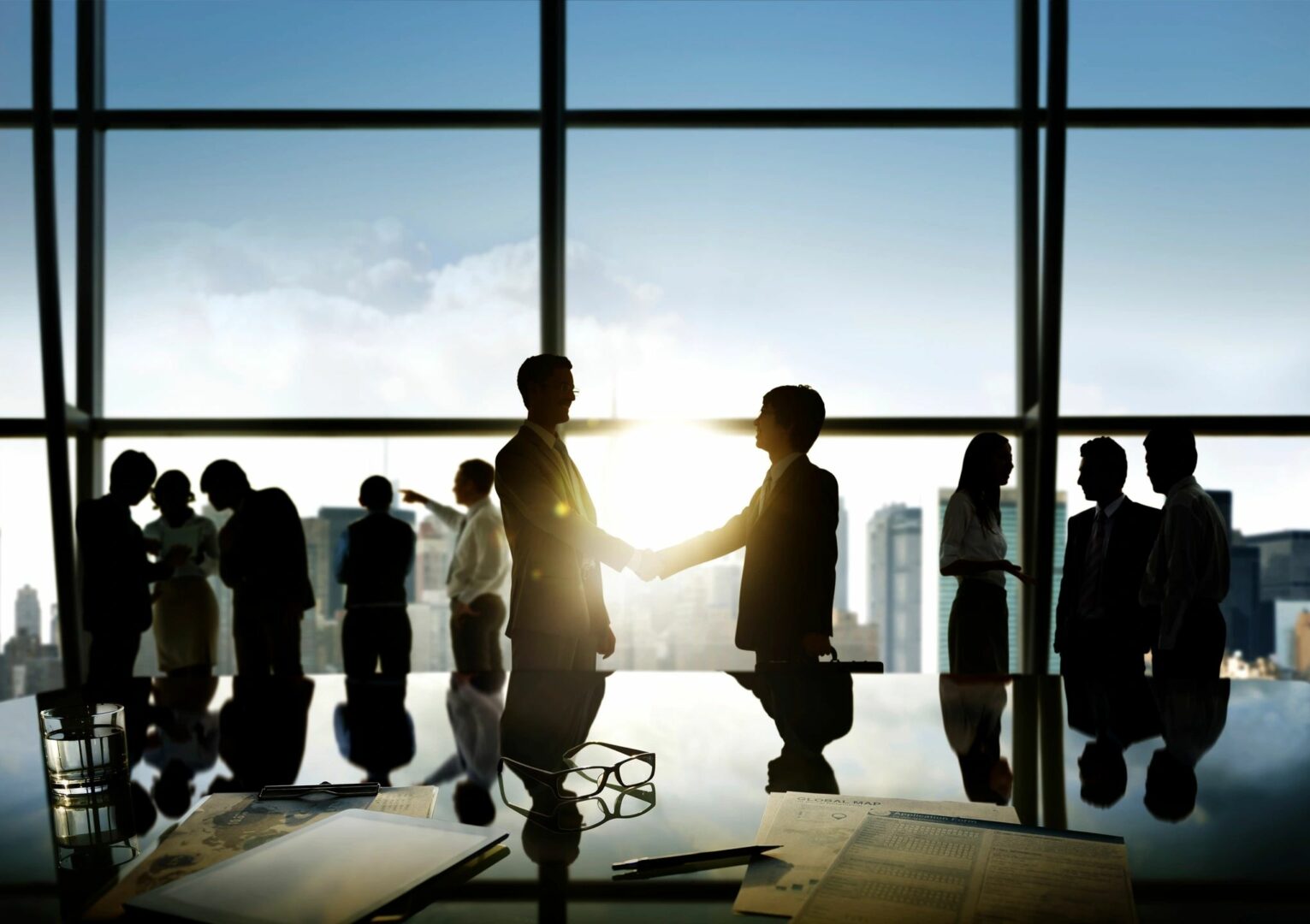 Two men shaking hands in front of a window.